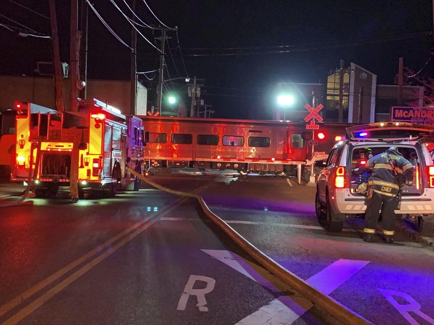 Firefighters work the scene of a collision involving a Manhattan-bound commuter train and a vehicle in Westbury, N.Y., Tuesday, Feb. 26, 2019. The Long Island Rail Road says service was suspended Tuesday evening in both directions on the Ronkonkoma and Huntington/Port Jefferson branches. (Howard Schnapp/Newsday via AP)