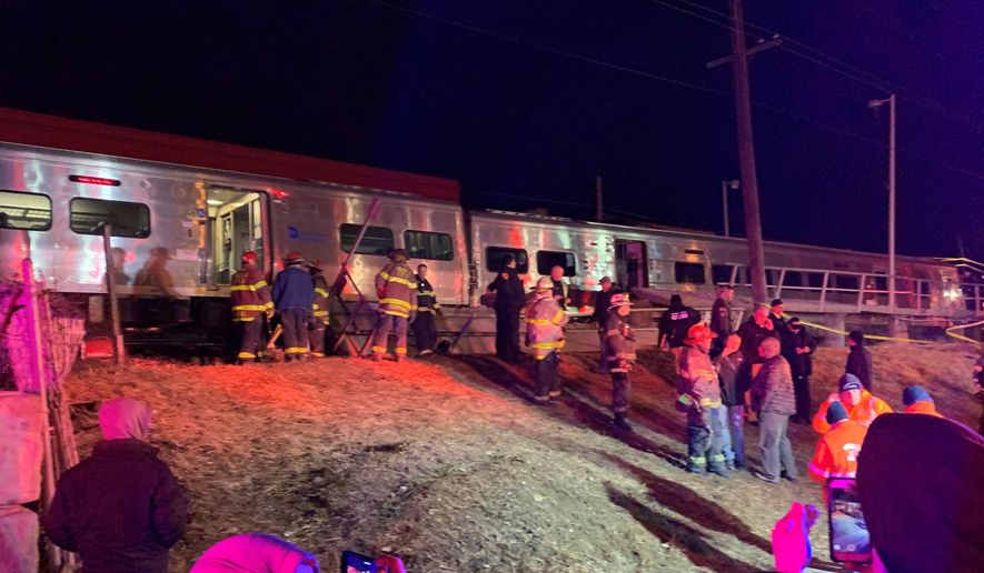 First responders work the scene of a collision involving a Manhattan-bound commuter train and a vehicle in Westbury, N.Y., Tuesday, Feb. 26, 2019. The Long Island Rail Road says service was suspended Tuesday evening in both directions on the Ronkonkoma and Huntington/Port Jefferson branches. (Howard Schnapp/Newsday via AP)