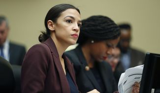 Rep. Alexandria Ocasio-Cortez, D-N.Y., left, looks over her notes during testimony by Michael Cohen, President Donald Trump&#39;s former lawyer, before the House Oversight and Reform Committee on Capitol Hill in Washington, Wednesday, Feb. 27, 2019. Sitting next to Ocasio-Cortez is Rep. Ayanna Pressley, D-Mass., right. (AP Photo/Pablo Martinez Monsivais)