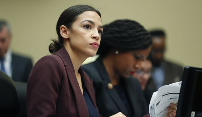 Rep. Alexandria Ocasio-Cortez, D-N.Y., left, looks over her notes during testimony by Michael Cohen, President Donald Trump&#x27;s former lawyer, before the House Oversight and Reform Committee on Capitol Hill in Washington, Wednesday, Feb. 27, 2019. Sitting next to Ocasio-Cortez is Rep. Ayanna Pressley, D-Mass., right. (AP Photo/Pablo Martinez Monsivais)