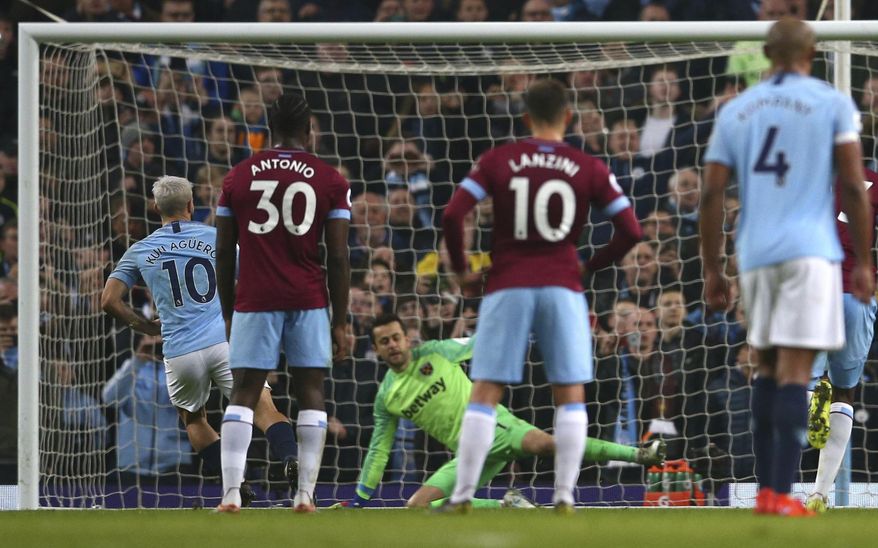 Manchester City's Sergio Aguero, left, shoots to score from the penalty spot during the English Premier League soccer match between Manchester City and West Ham United at Etihad stadium in Manchester, England, Wednesday, Feb. 27, 2019. (AP Photo/Dave Thompson)