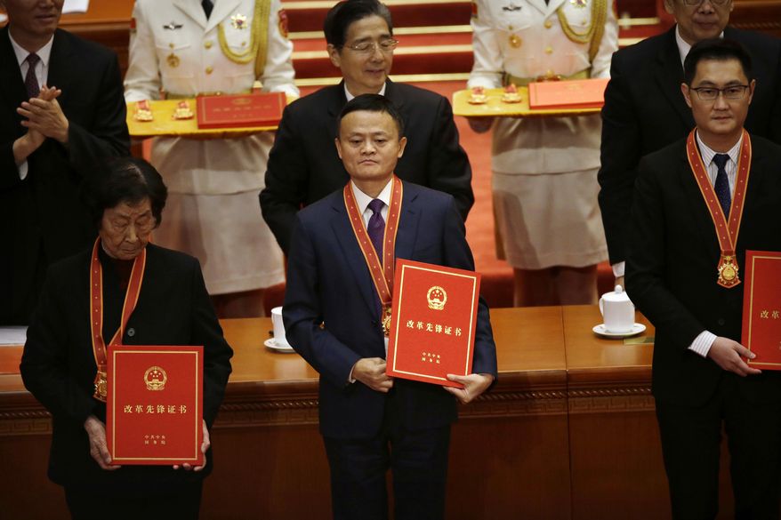 FILE - In this Dec. 18, 2018, file photo, Jack Ma, center, chairman of Chinese e-commerce firm Alibaba Group, stands during a conference to commemorate the 40th anniversary of China's Reform and Opening Up policy at the Great Hall of the People in Beijing. A rich list by wealth compiler Hurun Report shows the market meltdowns in 2018 obliterated $1 trillion in wealth, with more than 212 of China's richest individuals losing their dollar billionaire status. (AP Photo/Mark Schiefelbein, File)