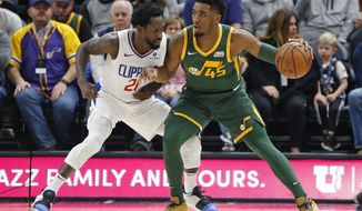 Los Angeles Clippers guard Patrick Beverley (21) guards Utah Jazz guard Donovan Mitchell (45) in the first half during an NBA basketball game Wednesday, Feb. 27, 2019, in Salt Lake City. (AP Photo/Rick Bowmer)