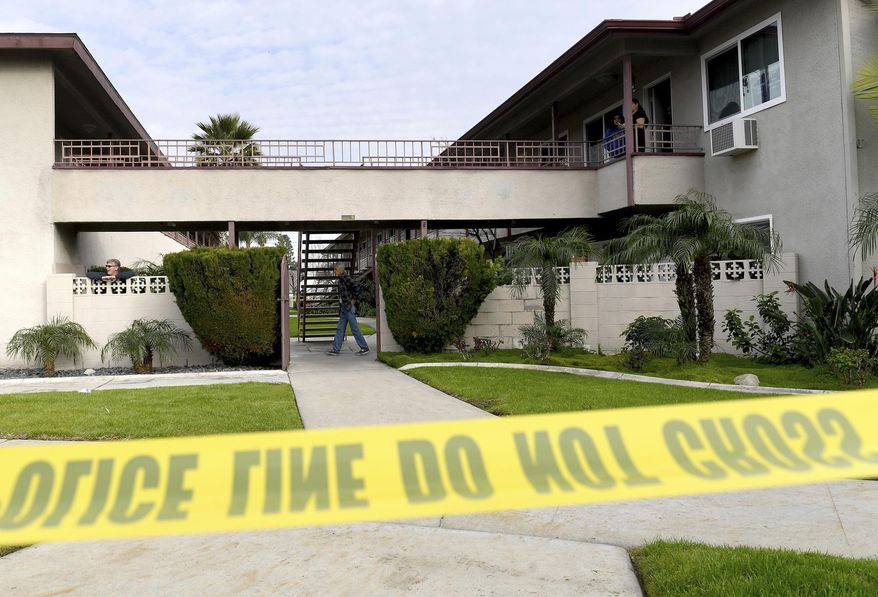 Residents mill about as Upland police investigate the scene, where police say a mother threw her young son from the second-story balcony of an apartment complex and then jumped herself as police arrived, in Upland, Calif., on Tuesday, Feb. 26, 2019. Police made a safety check of the second-story apartment and found the woman's approximately 7-month-old daughter inside. Her breathing was restored but she died at a hospital. (Jennifer Cappuccio Maher/The Orange County Register via AP)