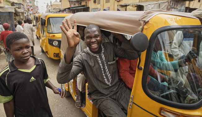A supporter of Nigeria&#x27;s President Muhammadu Buhari holds up four fingers to indicate &amp;quot;four more years&amp;quot;, in the streets of Kano, northern Nigeria, Wednesday, Feb. 27, 2019. Buhari was declared the clear winner of a second term in Africa&#x27;s largest democracy early Wednesday, after a campaign in which he urged voters to give him another chance. (AP Photo/Ben Curtis)