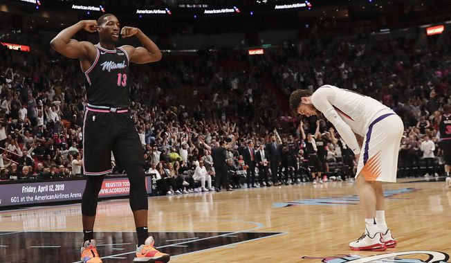 Miami Heat center Bam Adebayo (13) and Phoenix Suns guard Tyler Johnson, right, react during the second half of an NBA basketball game Monday, Feb. 25, 2019, in Miami. (AP Photo/Brynn Anderson)