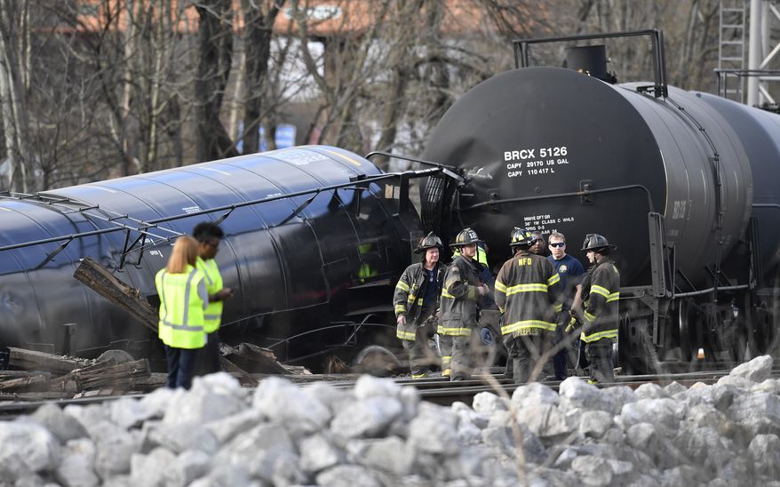 Emergency personnel work at the scene of a train derailment Wednesday, Feb. 27, 2019, in Nashville, Tenn. At least five cars derailed, some completely overturned off the tracks and two of which spilled their contents of soybean oil and barley. (George Walker IV/The Tennessean via AP)