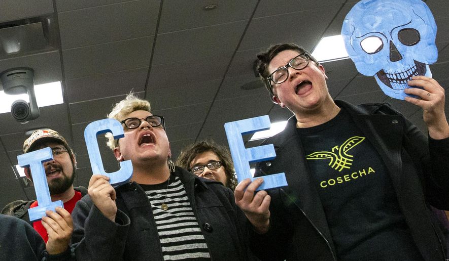 In this Tuesday, Feb. 26, 2019 photo, protesters interrupt a Grand Rapids City Commission meeting in Grand Rapids, Mich. Civil rights groups allege Grand Rapids police officials acted on racial profiling not fear of terrorism when they called federal immigration authorities on a former U.S. Marine who is Latino. Jilmar Ramos-Gomez was arrested in November 2018 after setting a small fire inside Spectrum Health Butterworth Hospital and then standing on the rooftop helipad. He was later held for three days by U.S. Immigration and Customs Enforcement, even though he was arrested with a U.S. passport. Grand Rapids Interim Police Chief David Kiddle said his department acted properly. (Cory Morse/The Grand Rapids Press via AP)