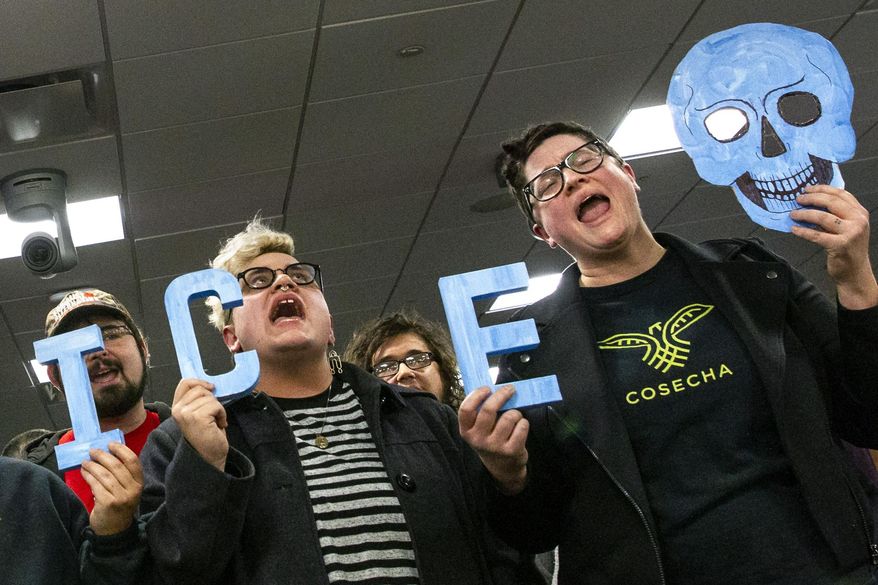 In this Tuesday, Feb. 26, 2019 photo, protesters interrupt a Grand Rapids City Commission meeting in Grand Rapids, Mich. Civil rights groups allege Grand Rapids police officials acted on racial profiling not fear of terrorism when they called federal immigration authorities on a former U.S. Marine who is Latino. Jilmar Ramos-Gomez was arrested in November 2018 after setting a small fire inside Spectrum Health Butterworth Hospital and then standing on the rooftop helipad. He was later held for three days by U.S. Immigration and Customs Enforcement, even though he was arrested with a U.S. passport. Grand Rapids Interim Police Chief David Kiddle said his department acted properly. (Cory Morse/The Grand Rapids Press via AP)