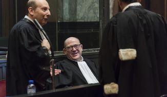 Lawyer Adrien Masset, representing the Jewish Museum, center, with other lawyers as he attends the trial of Mehdi Nemmouche at the Justice Palace in Brussels, Thursday, Feb. 28, 2019.  The defense lawyer Thursday is summing up the case for Nemmouche, who is charged with “terrorist murder” over the 2014 slaying of an Israeli couple and two employees at the Jewish museum in Brussels, about a week before the verdict is expected to be handed down.(AP Photo/Geert Vanden Wijngaert, Pool)