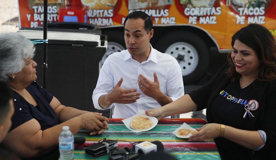 Former Housing and Urban Development Secretary and Democratic presidential candidate Julian Castro speaks with Lupe Arreola, left, Astrid Silva, right, and others while visiting a taco truck, Thursday, Feb. 28, 2019, in North Las Vegas, Nev. (AP Photo/John Locher)