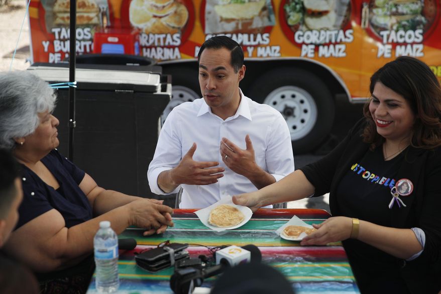 Former Housing and Urban Development Secretary and Democratic presidential candidate Julian Castro speaks with Lupe Arreola, left, Astrid Silva, right, and others while visiting a taco truck, Thursday, Feb. 28, 2019, in North Las Vegas, Nev. (AP Photo/John Locher)