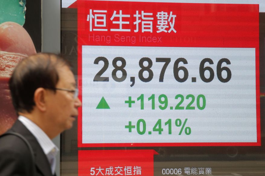 A man walks past an electronic board showing Hong Kong share index outside a bank in Hong Kong, Thursday, Feb. 28, 2019. Asian shares are mixed as investors fret over the status of China-U.S. trade talks after U.S. benchmarks closed mostly lower. (AP Photo/Kin Cheung)