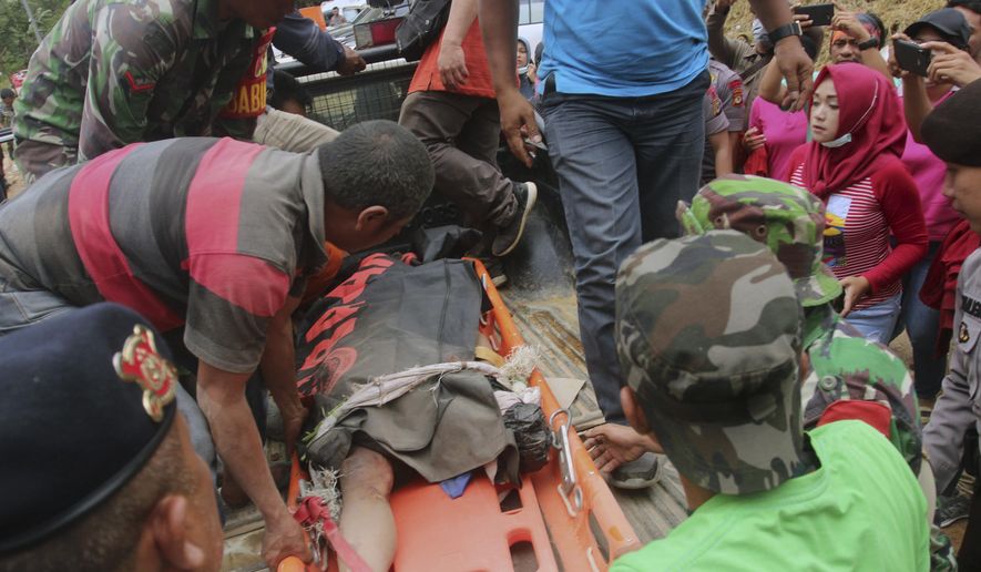 Rescuers load the body of a victim of a collapsed mine onto a truck in Bolaang Mongondow, North Sulawesi, Indonesia, Thursday, Feb. 28, 2019. Rescuers have passed water and food to some of the dozens of people trapped in a collapsed Indonesian gold mine, an official said Thursday, calling the gruelling rescue effort a race against time, in the remote inaccessible location. ((AP Photo/Harry Tri Atmojo)