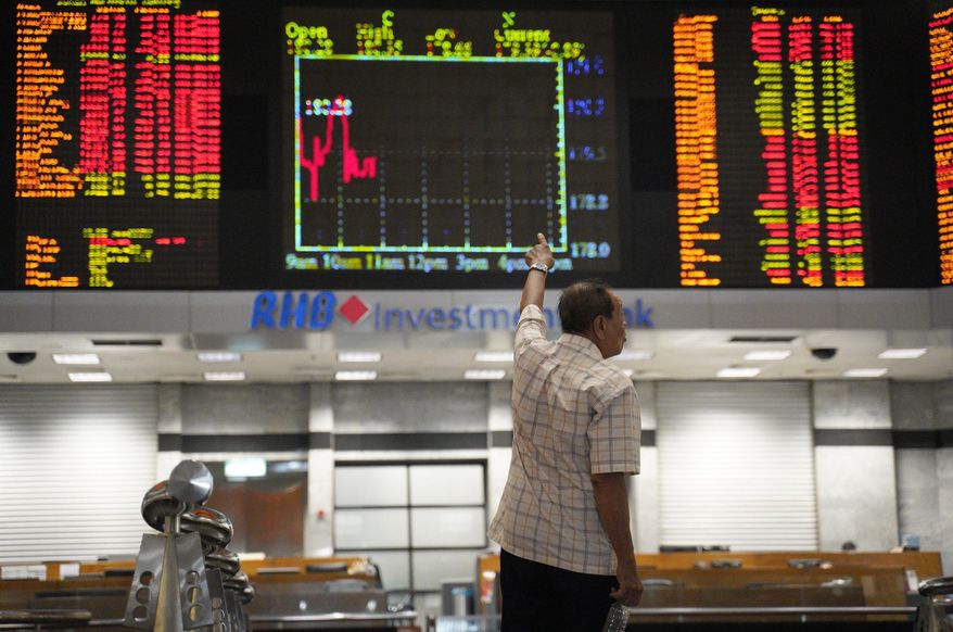 A visitor stands in front of private stock trading boards at a private stock market gallery in Kuala Lumpur, Malaysia, Friday, March 1, 2019. Asian stocks were mostly higher on Friday after a report suggested that the leaders of China and the U.S. could be endorsing a trade deal in weeks. (AP Photo/Yam G-Jun)