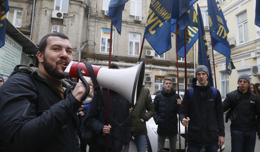 Volunteers with the right-wing paramilitary Azov National Corps attend a rally in front of the office of the city court in Kiev, Ukraine, Thursday, Feb. 28, 2019. President of Ukraine Petro Poroshenko suspended from office Oleh Hladkovsky, First Deputy Secretary of the National Security and Defense Council, pending the probe following a journalistic investigative report on corruption.(AP Photo/Efrem Lukatsky)