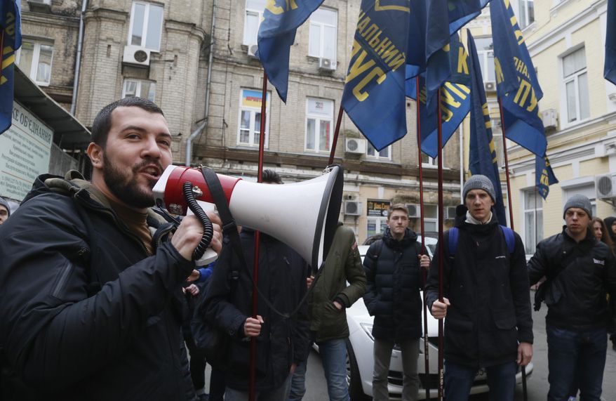 Volunteers with the right-wing paramilitary Azov National Corps attend a rally in front of the office of the city court in Kiev, Ukraine, Thursday, Feb. 28, 2019. President of Ukraine Petro Poroshenko suspended from office Oleh Hladkovsky, First Deputy Secretary of the National Security and Defense Council, pending the probe following a journalistic investigative report on corruption.(AP Photo/Efrem Lukatsky)