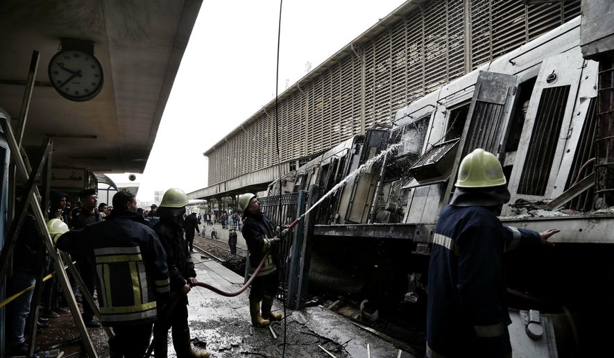 Firefighters hose down a train that was damaged after a crash inside Ramsis train station in Cairo, Egypt, Wednesday, Feb. 27, 2019. An Egyptian medical official said at least 20 people have been killed and dozens injured after a railcar rammed into a barrier inside the station causing an explosion of the fuel tank and triggering a huge blaze that engulfed that part of the station. The head of the Cairo Railroad Hospital said the death toll is expected to rise further. (AP Photo/Nariman El-Mofty) ** FILE **