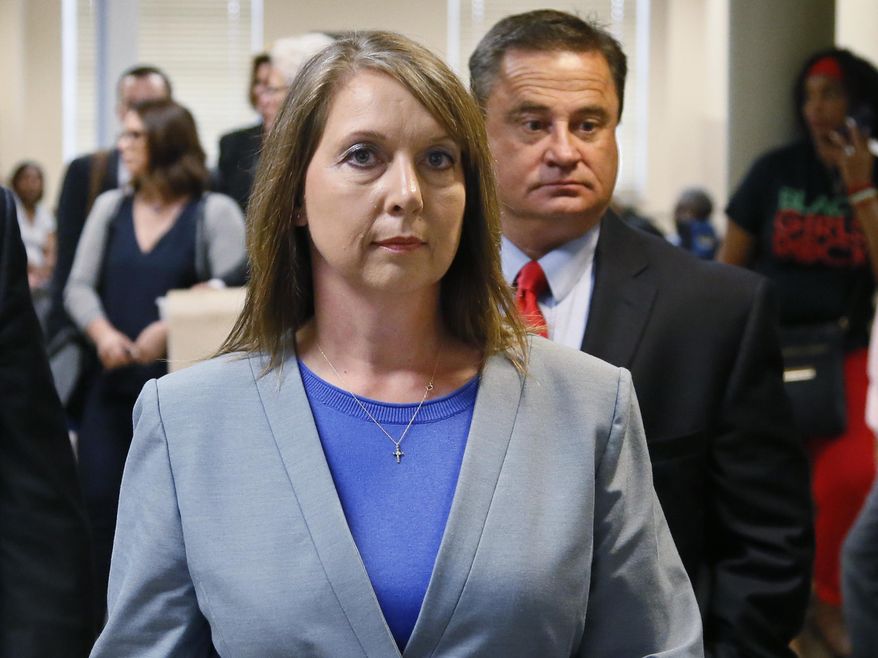 FILE - In this Wednesday, May 17, 2017 file photo, Betty Shelby leaves the courtroom with her husband, Dave Shelby, right, after the jury in her case began deliberations in Tulsa, Okla. The Department of Justice says there is insufficient evidence to pursue federal civil rights charges against the white former Tulsa police officer who shot and killed an unarmed black man. U.S. Attorney Trent Shores on Friday, March 1, 2019, announced the closure of the federal investigation into whether ex-Tulsa police officer Betty Shelby willfully used unreasonable force against Terence Crutcher when she shot and killed him in September 2016. (AP Photo/Sue Ogrocki, File)