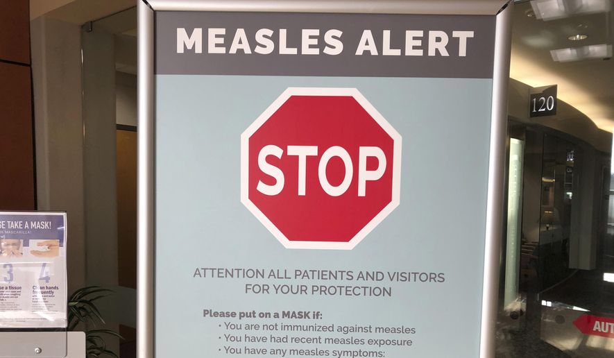 File - In this Jan. 30, 2019, file photo, a sign posted at The Vancouver Clinic in Vancouver, Wash., warns patients and visitors of a measles outbreak. The focus on measles in the Pacific Northwest intensified Friday, March 1, 2019, as public health officials in Oregon announced a new case of the highly contagious disease unrelated to an ongoing outbreak in Washington state that&#39;s sickened 68 people so far. (AP Photo/Gillian Flaccus, File) **FILE**
