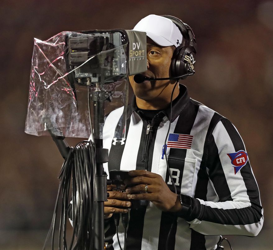 FILE - In this Nov. 3, 2018, file photo, referee Reggie Smith reviews a targeting penalty during the first half of an NCAA college football game between Oklahoma and Texas Tech, in Lubbock, Texas. The NCAA football rules committee has proposed giving replay officials more leeway to overturn targeting fouls. The rules committee met in Indianapolis this week and announced on Friday, March 1, 2019, its proposed changes. The proposals must be approved by the football oversight committee in April. They would go into effect next season. (AP Photo/Brad Tollefson, File)
