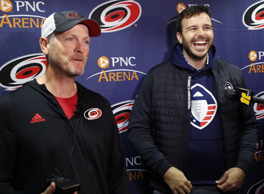 FILE - In this Feb. 19, 2019, file photo, Tom Dundon, left, majority owner of the Carolina Hurricanes, and Charlie Ebersol, co-founder and CEO of the Alliance of American Football, talk to the media about Dundon's $250 million investment in the league, before an NHL hockey game between the New York Rangers and the Hurricanes in Raleigh, N.C. Its too early to tell what impact the Alliance of American Football will have on the sport itself. After all, this is its fourth weekend of games. Away from the field, with an infusion of backing from Dundon, the AAF is finding its footing. Its also finding what Ebersol calls substantial interest in the league in such areas as sponsorships and partnerships, with three new partners signing on since the season opener three weeks ago. (AP Photo/Chris Seward, File) **FILE**
