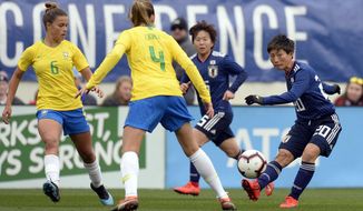 Japan forward Kumi Yokoyama (20) passes the ball past Brazil defenders Tamires (6) Erika (4) during the first half of a SheBelieves Cup women&#39;s soccer match Saturday, March 2, 2019, in Nashville, Tenn. (AP Photo/Mark Zaleski)