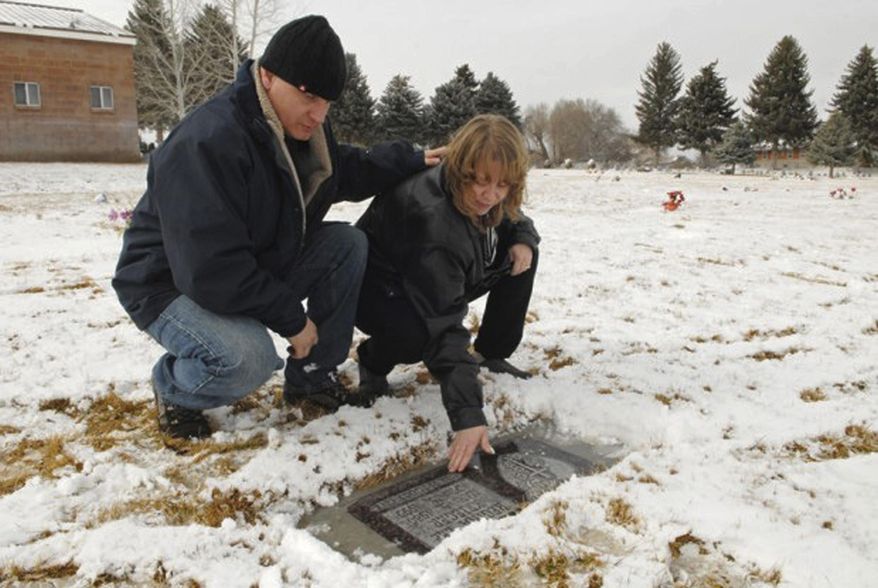 FILE - In this Feb. 2011 file photo, Rhonda and Jim Hunnel visit the grave of Rhonda's slain daughter, Regina Krieger, in Burley, Idaho. If anyone is justified in feeling hate, it would be the mother of a teen whose murder went unsolved for more than two decades. But as Rhonda Hunnel prepares for the trial of the man who police now say killed her 14-year-old daughter 24 years ago, she asks that others extend forgiveness and love instead of hate. (Laurie Welch/The Times-News via AP, File)