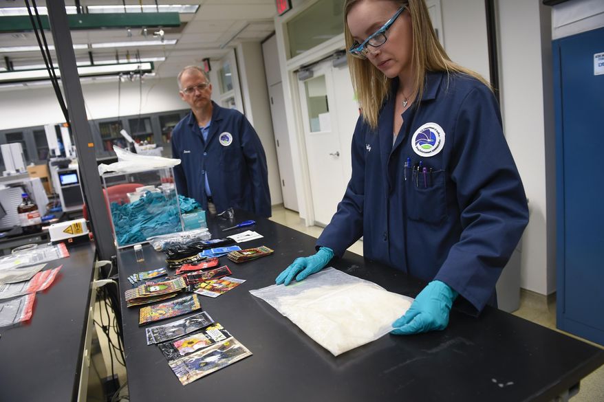 This photo taken Feb. 19, 2019, shows Emily Lockhart, a senior forensic chemist at the Drug Enforcement Administration's Special Testing and Research Laboratory in Sterling, Va., with a bag of crystal methamphetamine. (Jack Gruber/USA Today via AP)