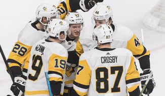 Pittsburgh Penguins&#39; Jake Guentzel (59) celebrates with teammates Sidney Crosby (87), Jared McCann (19), Erik Gudbranson (44) and Marcus Pettersson (28) after scoring during the second period of an NHL hockey game, Saturday, March 2, 2019 in Montreal. (Graham Hughes/The Canadian Press via AP)