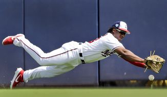 Washington Nationals right fielder Chuck Taylor dives but is unable to catch a ball hit for a single by Houston Astros&#39; Carlos Correa during the first inning of an exhibition spring training baseball game Sunday, March 3, 2019, in West Palm Beach, Fla. (AP Photo/Jeff Roberson)