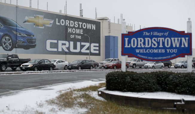FILE - In this Nov. 27, 2018, file photo, a banner depicting the Chevrolet Cruze model vehicle is displayed at the General Motors&#x27; Lordstown plant, in Lordstown, Ohio. GM employees in Lordstown and other factories in Michigan and Maryland that are targeted to close within a year say moving will force them to leave behind relatives, even their children, in some cases. (AP Photo/John Minchillo, File)