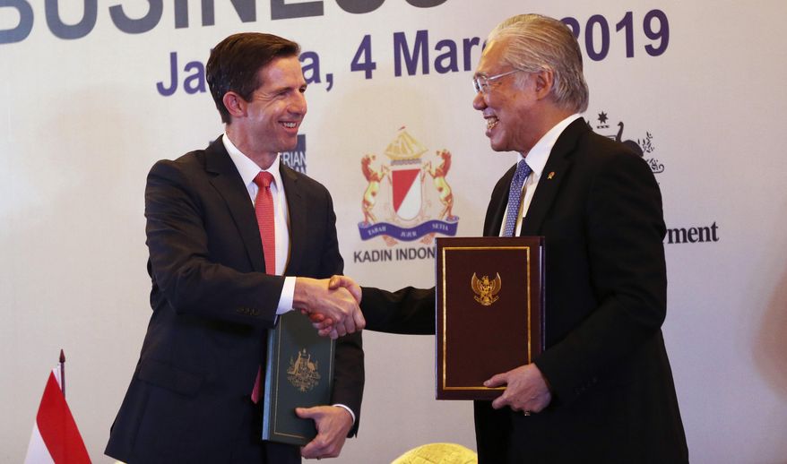 Australia Minister of Trade, Tourism and Investment Simon Birmingham, left, and Indonesia Minister of Trade Enggartiasto Lukita, right, shake hands during an Indonesia-Australia Cepa signing ceremony and Business forum in Jakarta, Indonesia, Monday, March 4, 2019. (AP Photo/Achmad Ibrahim)