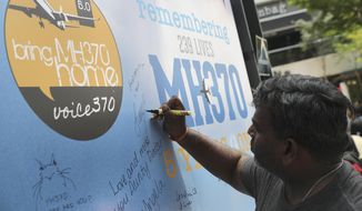 A man writes a condolence message during a Day of Remembrance for MH370 event in Kuala Lumpur, Malaysia, Sunday, March 3, 2019. Five years ago, Malaysia Airlines Flight MH370, a Boeing 777, had gone missing the day before while over the South China Sea with 239 people on board. (AP Photo/Vincent Thian) **FILE**