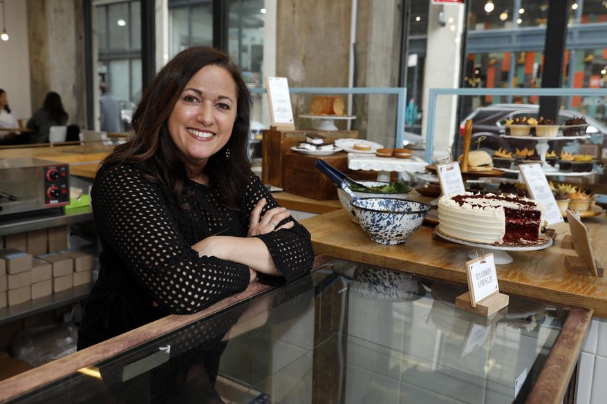 In this Wednesday, Feb. 6, 2019 photo, Dawn Casale, founder of One Girl Cookies, poses for photos in her shop in the Dumbo neighborhood of the Brooklyn borough of New York.  Mayor Bill de Blasio wants New York to become the first place in the 50 states to make private businesses provide time off with pay. Employees at Casale's bakery get paid time off after five years, or if they're managers; others can arrange unpaid vacation, she said. "I would love to be able to provide vacation time to my employees ... but the reality of it is not whether or not we want to give it — it's whether we can give it," said Casale. (AP Photo/Richard Drew)