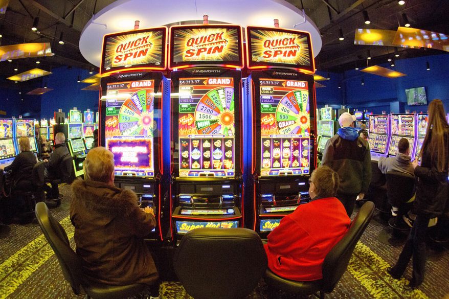 In this Feb. 14, 2019 photo, patrons play the slot-style machines at the Ponca Tribe's Prairie Flower Casino in Carter Lake, Iowa. Some 150 years after suffering the loss of tribal lands and near-extinction at the hands of the U.S. government, the Ponca Tribe of Nebraska is celebrating a triumph with the opening of a casino intended to secure a stream of revenue for the long-struggling tribe, but is fighting to keep it open in the face of lawsuits by officials in Nebraska and Iowa. (AP Photo/Nati Harnik)