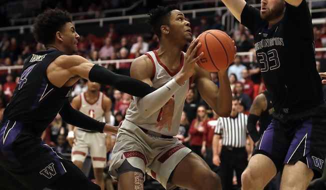 Stanford's KZ Okpala, center, looks to shoot between Washington's Sam Timmins (33) and Matisse Thybulle, left, in the first half of an NCAA college basketball game Sunday, March 3, 2019, in Stanford, Calif. (AP Photo/Ben Margot)