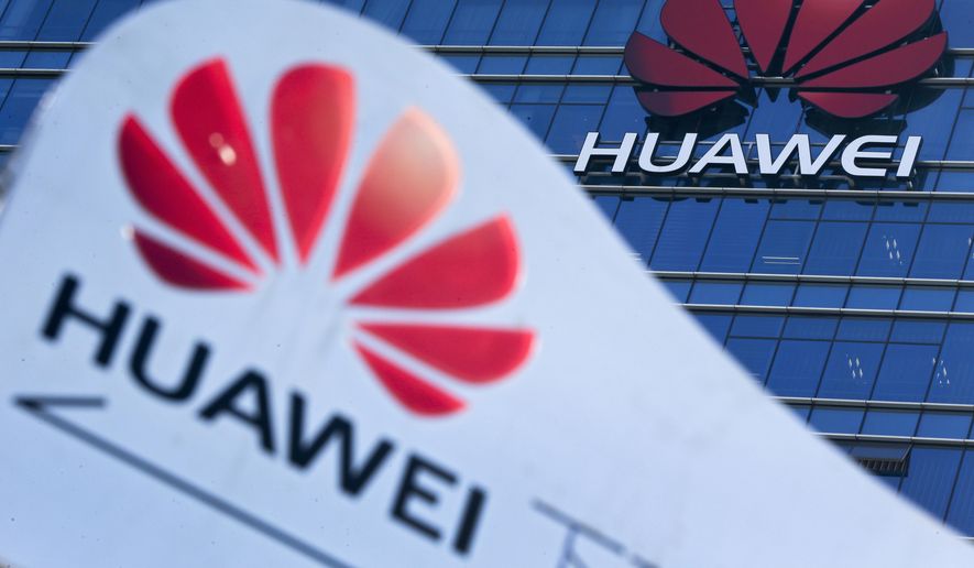 This Dec. 18, 2018, file photo, shows company signage on display near the Huawei office building at its research and development center in Dongguan, in south China's Guangdong province. China says the U.S. is using a double standard in claiming Chinese law requires telecoms giant Huawei to violate other countries' information security. (AP Photo/Andy Wong, File)
