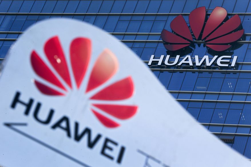 This Dec. 18, 2018, file photo, shows company signage on display near the Huawei office building at its research and development center in Dongguan, in south China's Guangdong province. China says the U.S. is using a double standard in claiming Chinese law requires telecoms giant Huawei to violate other countries' information security. (AP Photo/Andy Wong, File)