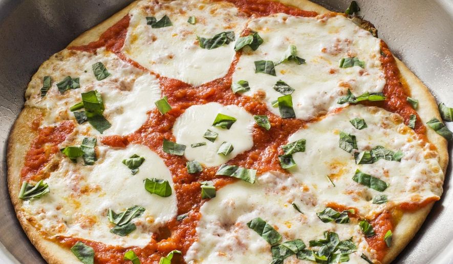 This undated photo provided by America's Test Kitchen in March 2019 shows skillet pizza displayed in Brookline, Mass. The recipe appears in the cookbook "Bread Illustrated." (Carl Tremblay/America's Test Kitchen via AP)