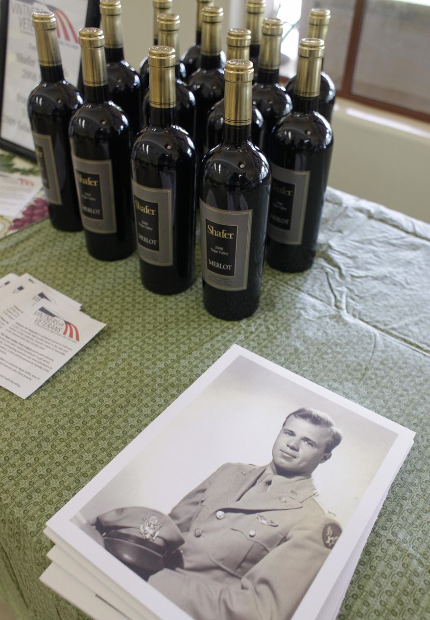File - In this April 17, 2011, file photo, bottles of Shafer Vineyards 2008 Merlot are on display by a World War II portrait of John Shafer during a lunch at the Veterans Home of California in Yountville, Calif. Northern California vintner and philanthropist John Shafer has died at the age of 94. He was part of a generation of vintners that transformed the sleepy Napa Valley into a region known the world over for its stellar wines. Shafer Vineyards announced Monday, March 4, 2019, that its founder died Saturday in Napa. (AP Photo/Eric Risberg, File)