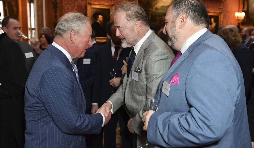 Britain's Prince Charles, the Prince of Wales, speaks with actor Owen Teale and singer Wynne Evans during a reception at Buckingham Palace, London, Tuesday March 5, 2019, to mark the fiftieth anniversary of the investiture of the Prince of Wales. (Dominic Lipinski/Pool via AP)