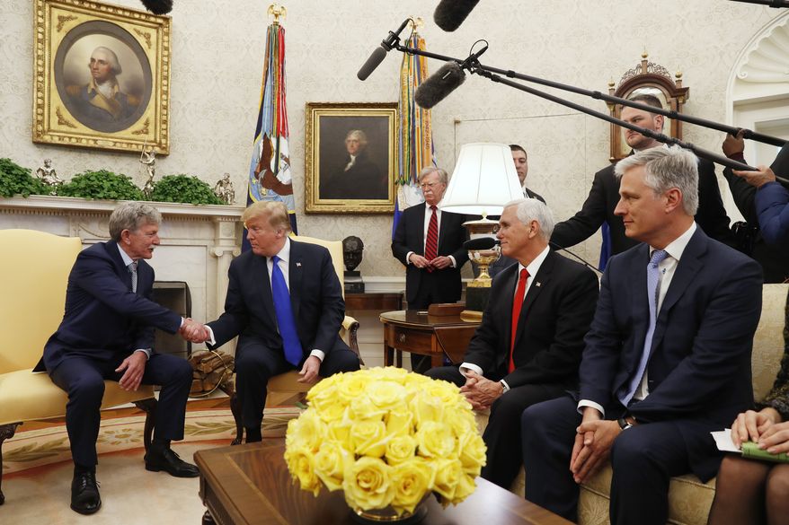 President Donald Trump shakes hands with former U.S. hostage in Yemen, Danny Burch, Wednesday, March 6, 2019, in the Oval Office of the White House in Washington, next to Vice President Mike Pence, and Special Presidential Envoy for Hostage Affairs Robert O'Brien. At back right of Trump is national security adviser John Bolton. (AP Photo/Jacquelyn Martin)