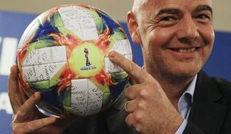 FILE - In this Feb. 27, 2019, file photo, FIFA President Gianni Infantino holds the official ball of the upcoming Women’s Soccer World Championship as he poses for photographers during a press conference at the end of an executive committee meeting in Rome. FIFA&#39;s financial results underscore the glaring disparity between men and women’s soccer. “We need to try to find what is the most balanced way and I think we made a step and there will be many more steps going ahead,” Infantino said in October before his ruling council approved the 2019 Women’s World Cup prize scale. (AP Photo/Gregorio Borgia, File)