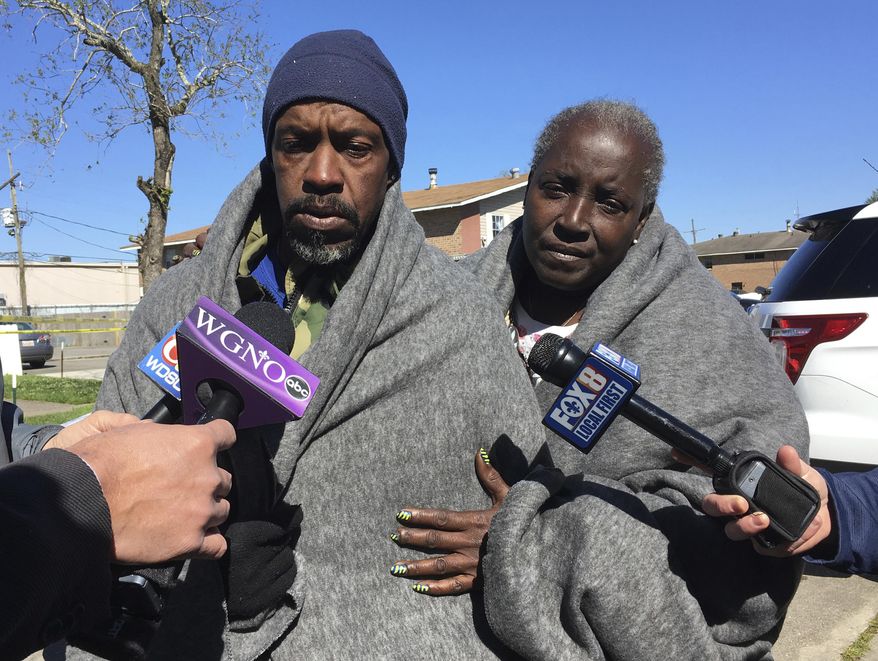 Emmett Rhodes, left, and neighbor Willie Tyson stand outside a house where authorities found a woman and two children killed and another woman and child critically injured, Wednesday, March 6, 2019 in Terrytown, La. Rhodes said his daughter and her three children were among the victims. (AP Photo/Kevin McGill)
