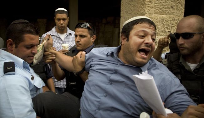 FILE - In this May 27, 2010 file photo, Israeli right wing activist Itamar Ben-Gvir is detained by police after shouting slogans at White House Chief of Staff Rahm Emanuel, during his visit to Jerusalem's Old City. Israel's central elections committee has rejected a motion to bar two members of an extreme Jewish nationalist party from running in April's parliamentary vote. The committee on Wednesday upheld the candidacy of Michael Ben Ari and Itamar Ben Gvir, leaders in the Jewish Power party. (AP Photo/Sebastian Scheiner, File)