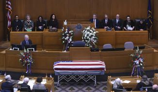 The casket of Oregon Secretary of State Dennis Richardson is surrounded by family, legislators and the public in the House Chambers during the state funeral at the Oregon State Capitol in Salem, Ore., Wednesday, March 6, 2019. (AP Photo/Steve Dykes)