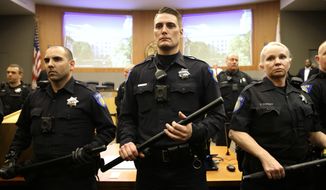 Baton carrying Sacramento Police Officers stand in front of the Sacramento City Council chambers as a disruption breaks out Tuesday, March 5, 2019, in Sacramento, Calif. Community members expressed anger over the decision by the Sacramento County District Attorney to not file criminal charges against the two police officers involved in the fatal shooting of Stephon Clark, 22, an unarmed vandalism suspect, last year. (AP Photo/Rich Pedroncelli)