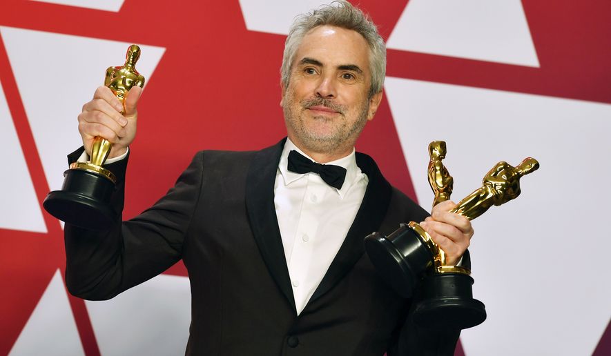 In this Sunday, Feb. 24, 2019, file photo, Alfonso Cuaron poses with the awards for best director for &quot;Roma,&quot; best foreign language film for &quot;Roma,&quot; and best cinematography for &quot;Roma&quot; in the press room at the Oscars at the Dolby Theatre in Los Angeles. “Roma” may not have won the best picture Oscar this year, but it came close enough to make some of Hollywood’s top players worry about Netflix’s infiltration of their most prestigious award. (Photo by Jordan Strauss/Invision/AP, File)