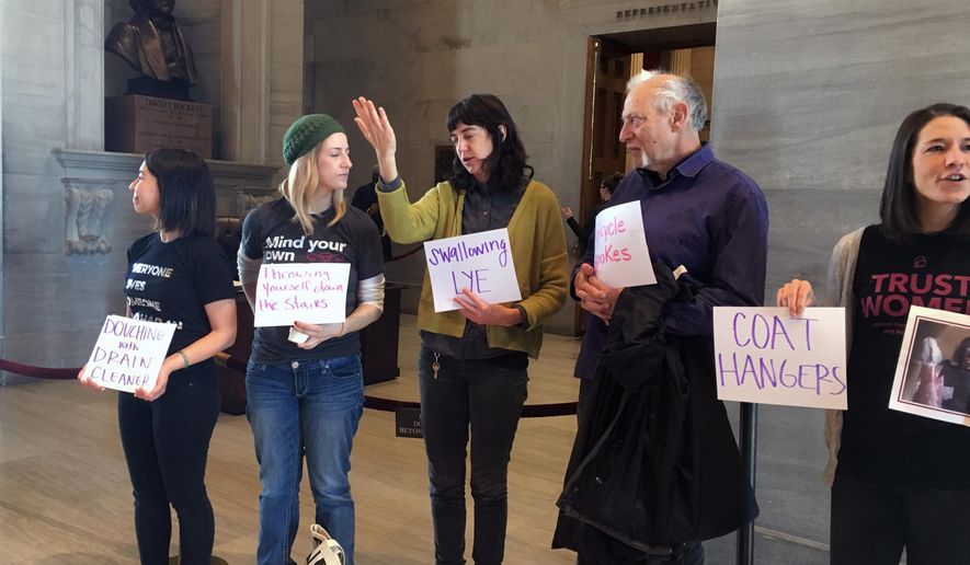 Protesters from Planned Parenthood and other groups gather in front of the Tennessee House chamber to oppose a so-called fetal heartbeat bill before the vote, Thursday, March 7, 2019 in Nashville, Tenn. House lawmakers on Thursday passed legislation that would ban most abortions once a fetal heartbeat is detected, about six weeks into pregnancy. The bill is almost guaranteed to face a lawsuit if it becomes law. (AP Photo/Jonathan Mattise)
